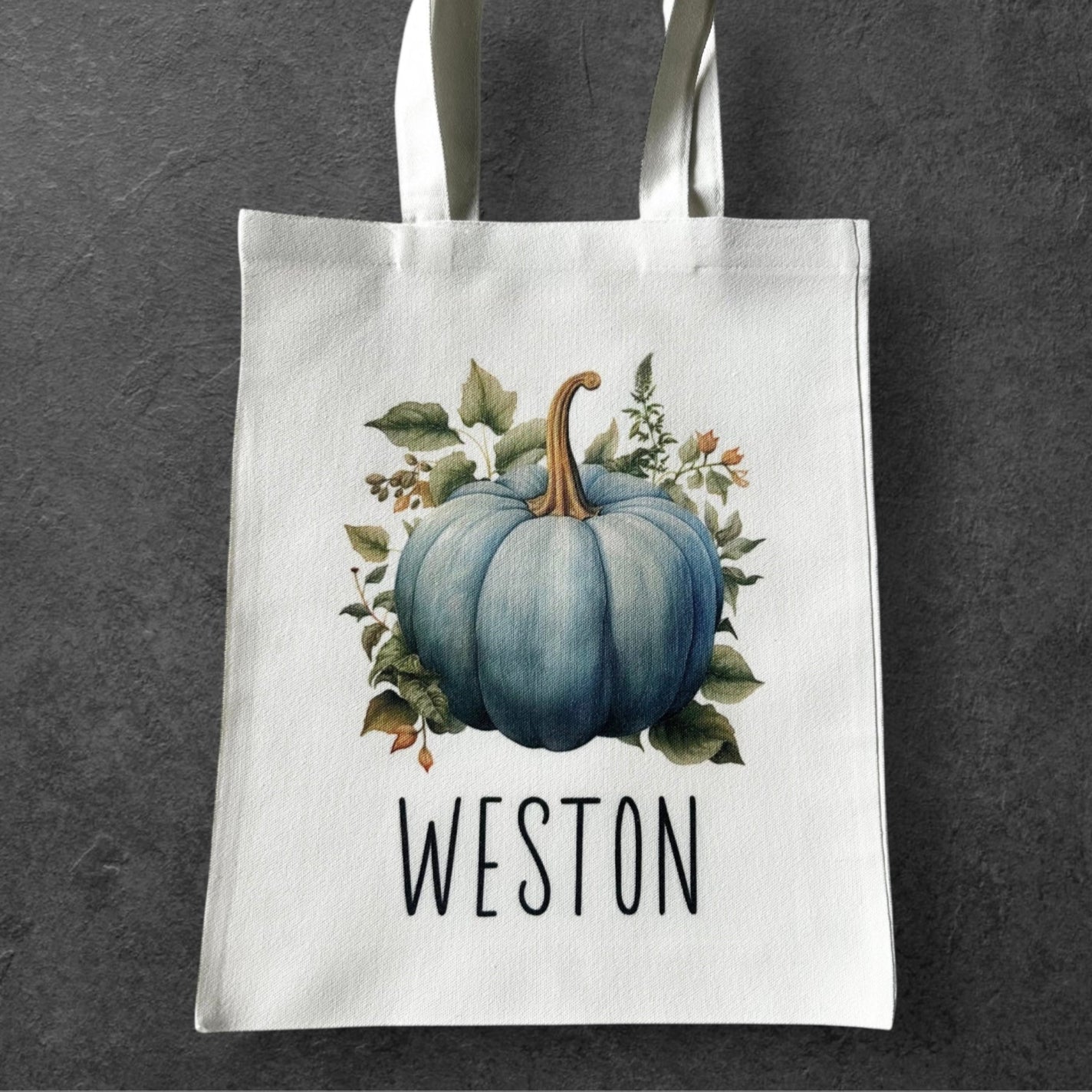 Tote bag with a blue pumpkin design and 'WESTON' text on a dark gray background